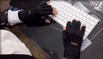 Wearing Copper Fit® Hand Relief typing on a keyboard at work